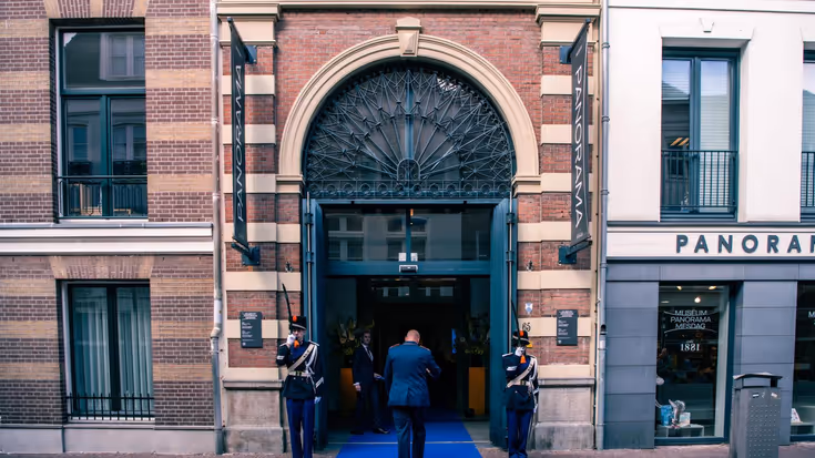 Twee militairen vormen een erewacht bij een entree.