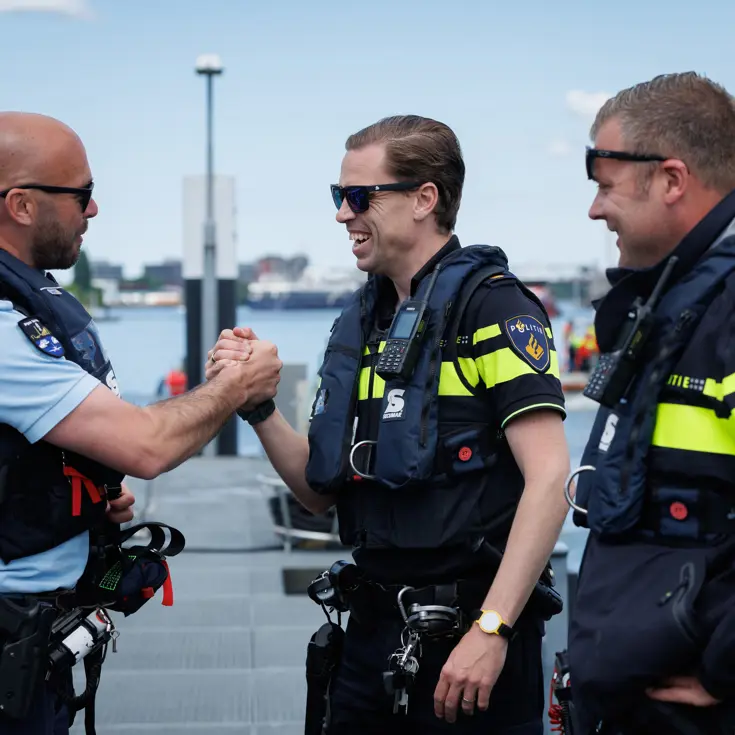 Een marechaussee schudt de hand van collega’s van de zeehavenpolitie. 