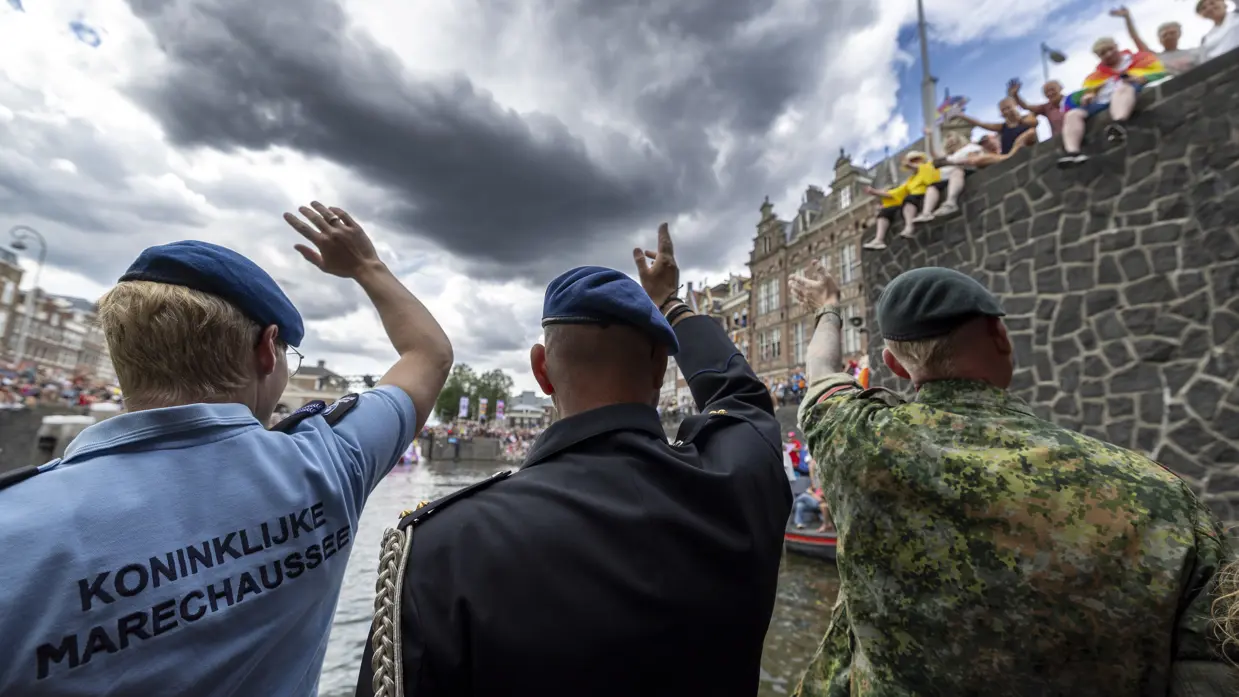 Militairen wuiven naar mensen die van boven naar hen kijken.