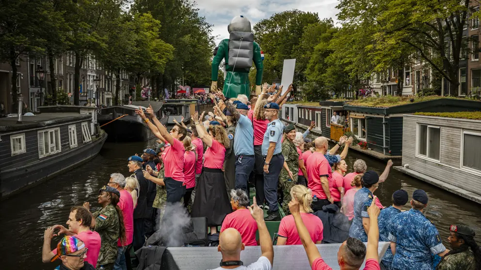 De defensieboot vaart door een Amsterdamse gracht. 