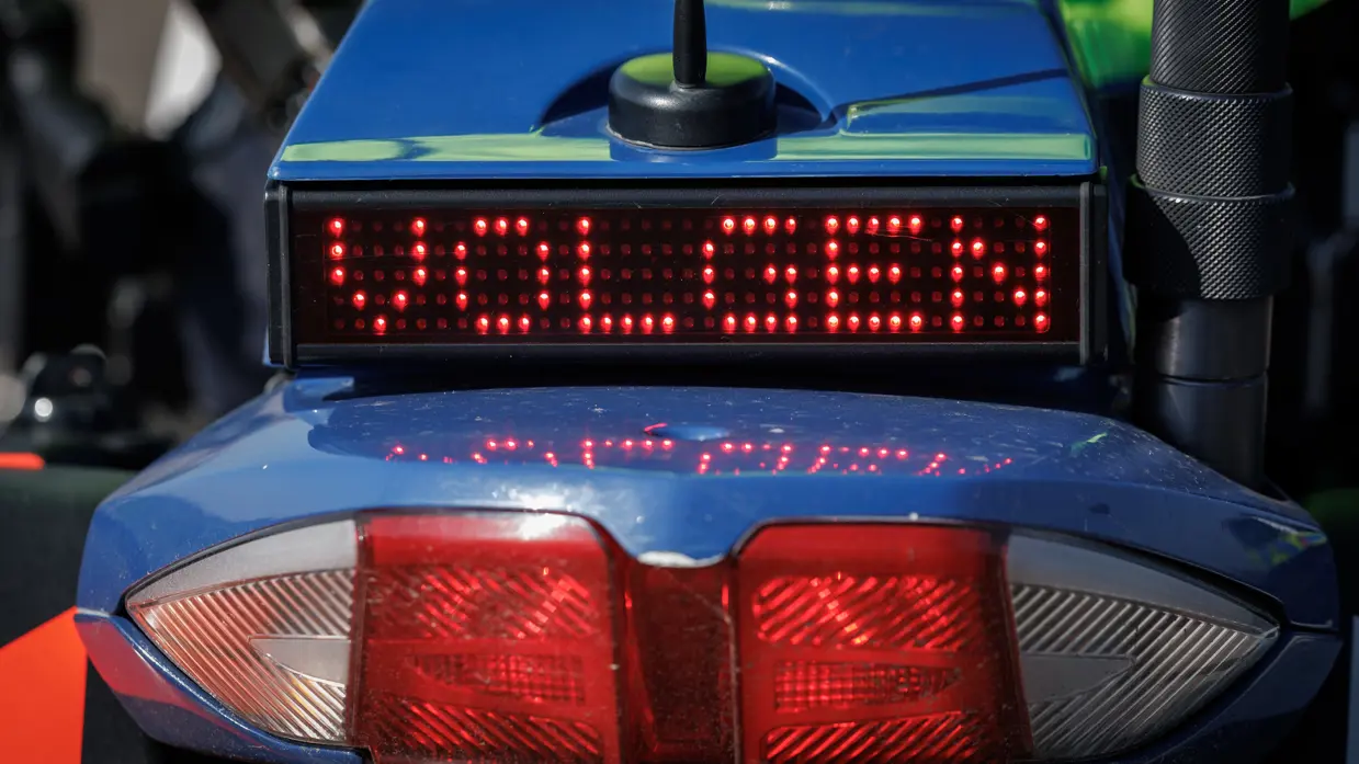Een sein ‘volgen’ achterop een motor van de Koninklijke Marechaussee.