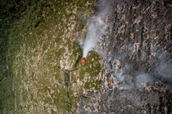 Een bambi bucket hangt onder een Chinook.