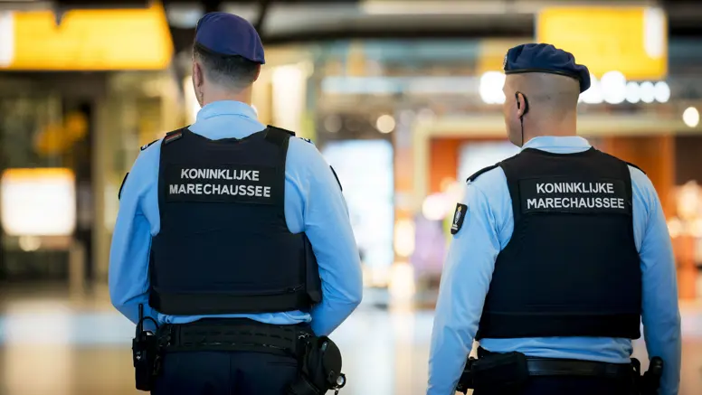 Twee marechaussees in operationeel tenue, op de rug gezien.