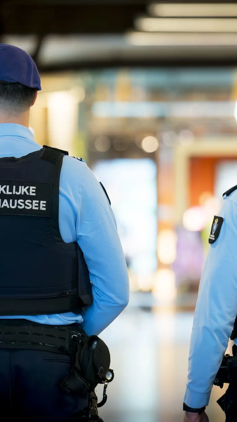 Twee marechaussees in operationeel tenue, op de rug gezien.