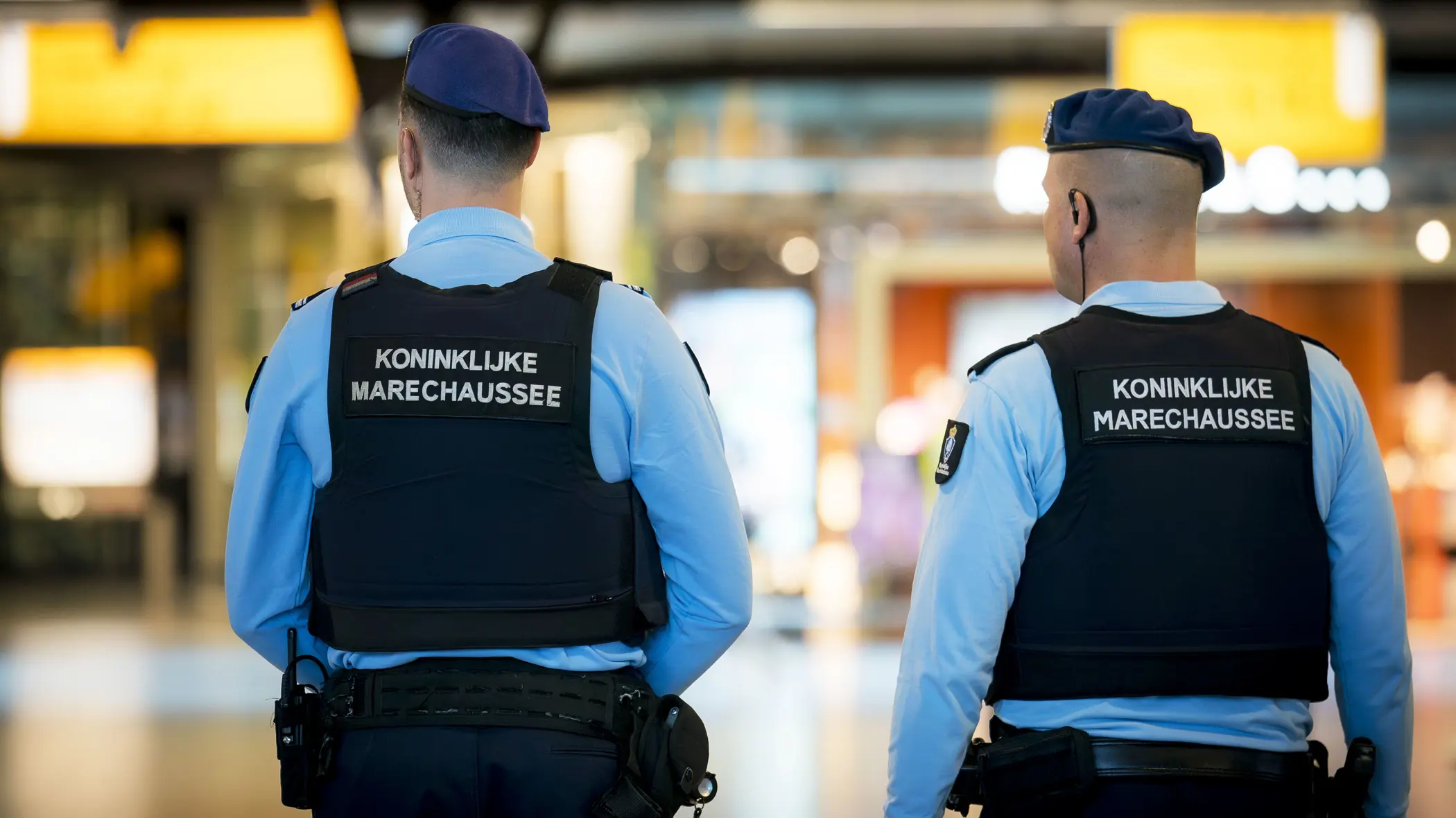Twee marechaussees in operationeel tenue, op de rug gezien.