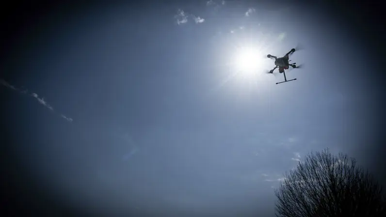 Een drone vliegt vlak voor de zon langs. De foto is bewerkt, waardoor er een zwarte rand rond het beeld is te zien.&nbsp;