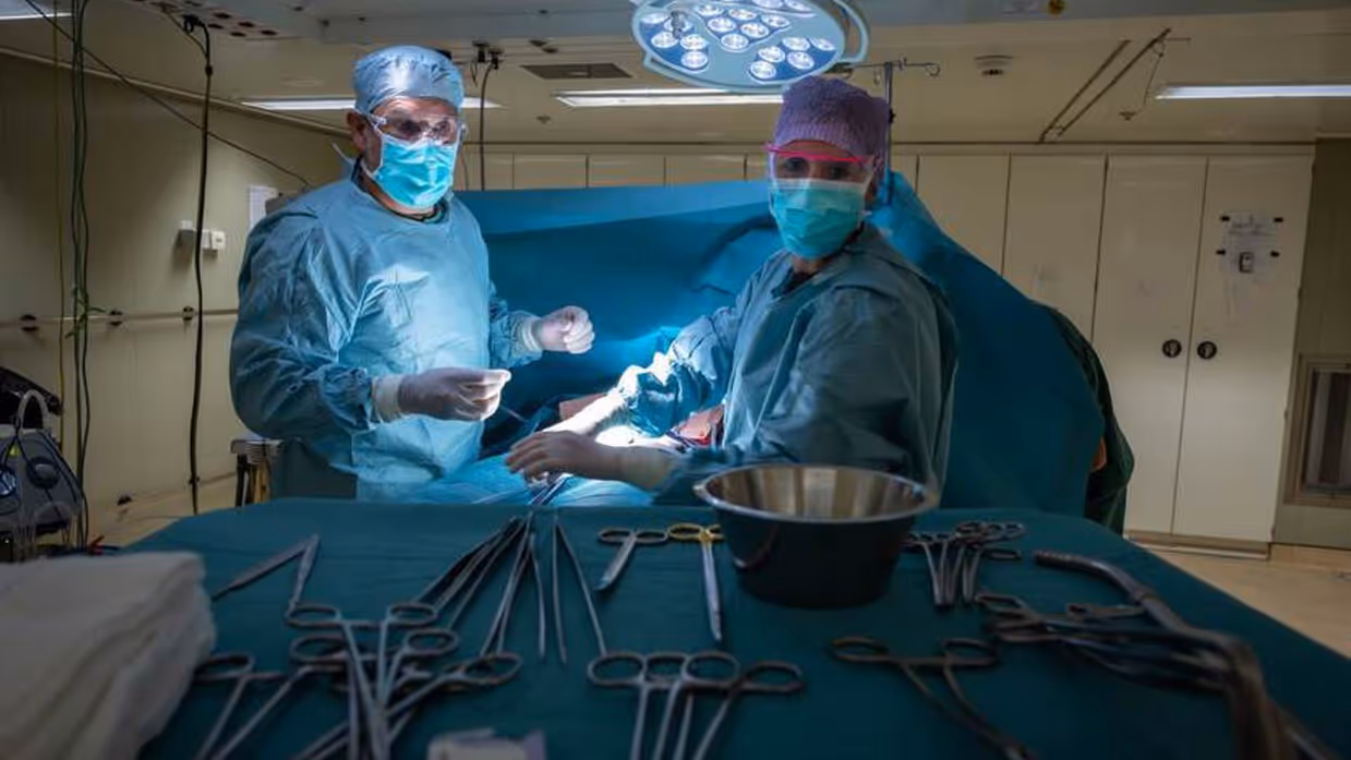 2 mensen van medisch team in het groen in een operatiekamer aan boord van een marineschip.een