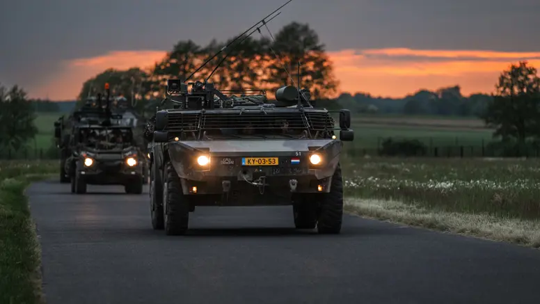 Personeel staande bij de Tracking Antenna Rotators met een drone hoverend op de voorgrond. 