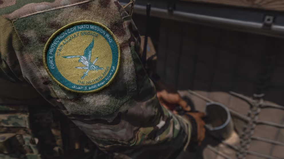 Logo van NAVO-missie op schouder van militair.