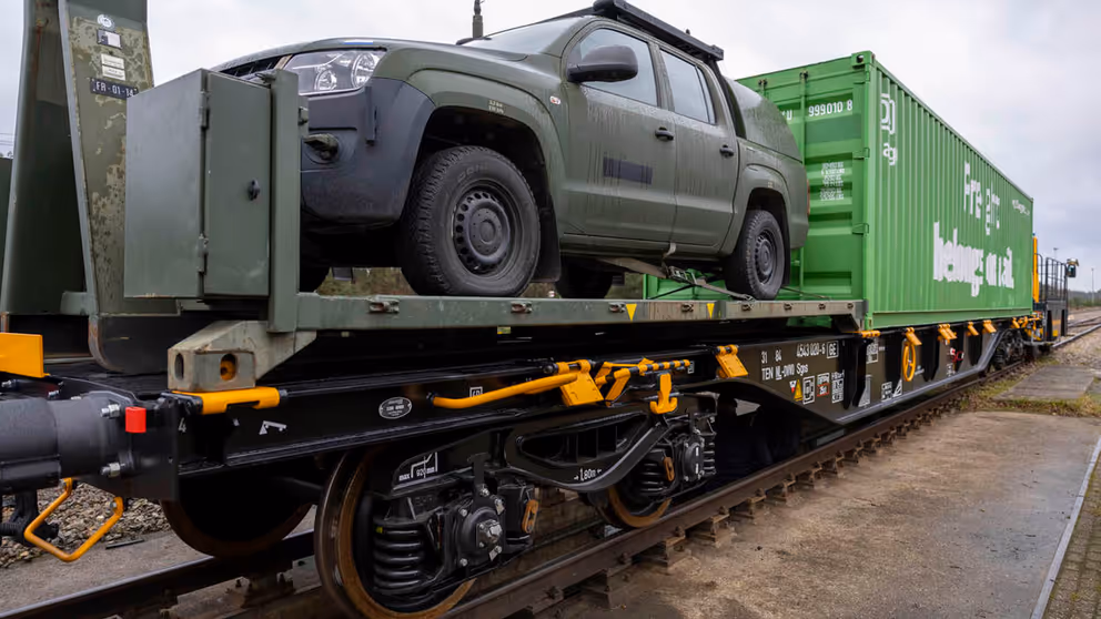 Containerwagon inclusief jeep staan klaar op spoor.