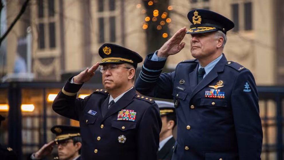 Generaal Yoshihide Yoshida en generaal Onno Eichelsheim staan naast elkaar en geven acht.
