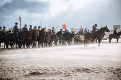Ruiters te paard op het strand.