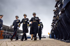 5 mariniers lopen langs een erehaag. 