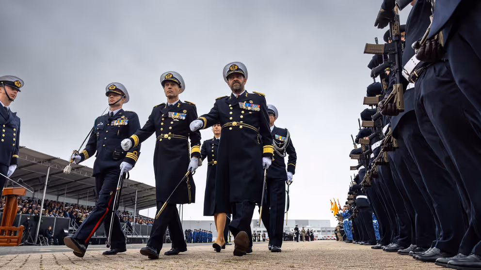 5 mariniers lopen langs een erehaag.