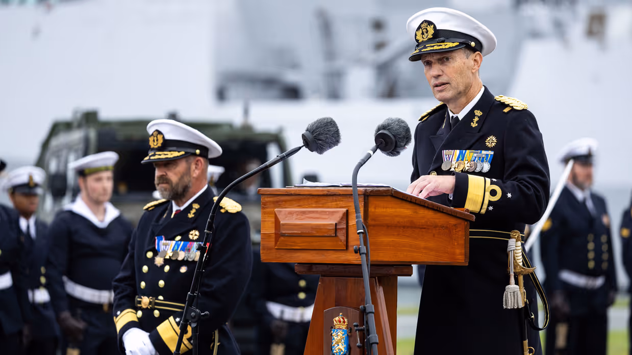 Liebregs staat achter een katheder. 