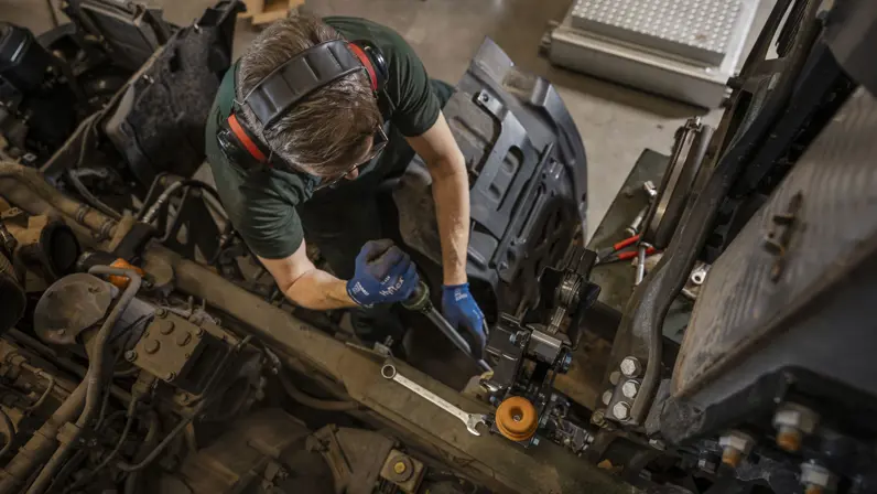 Monteur sleutelt aan chassis transportvoertuig.