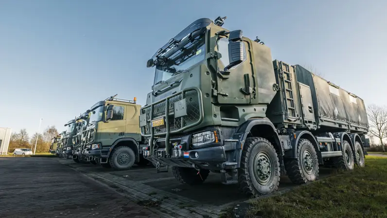 Bepantserde transportvoertuigen staan naast elkaar op parkeerplaats.