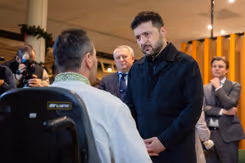 President Zelensky spreekt met een man in een rolstoel bij het Militair Revalidatiecentrum.