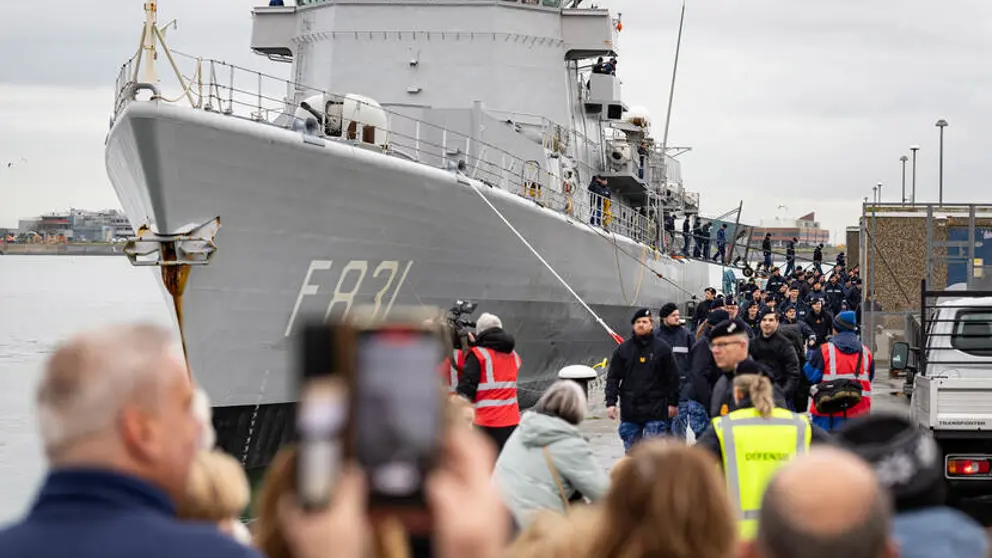Mariniers lopen op de wal naast Zr.Ms. Van Amstel. 
