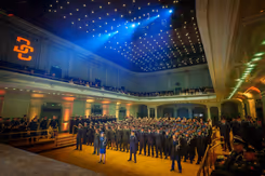 Zaal met honderden militairen die naar het podium staan te kijken.