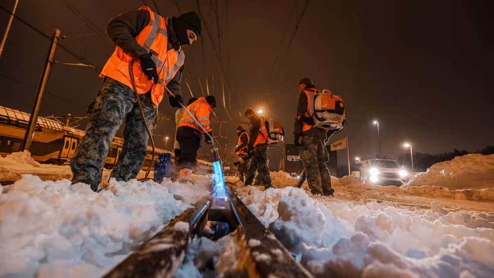 Militairen maken het spoor sneeuwvrij met een brander.