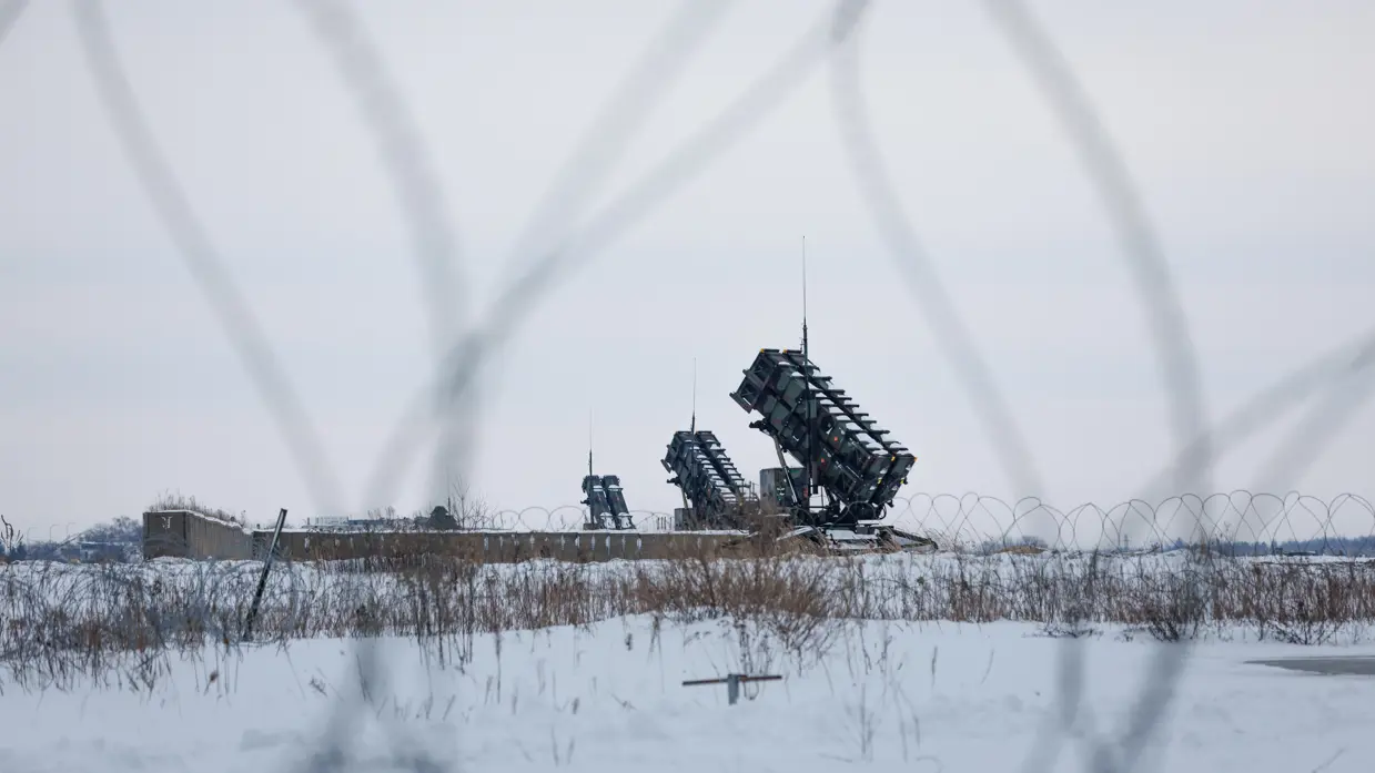 Op de linkerfoto verricht een militair handelingen aan een detectiemiddel met een soort antennes. Rechts staan lanceerinstallaties van de Patriot. 
