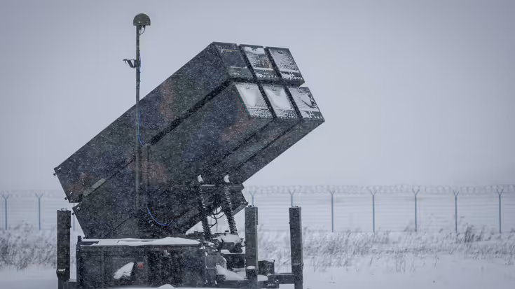 Links een counterdrone-apparaat met grote lenzen. Rechts een NASAMS-lanceerinstallatie in de sneeuw.