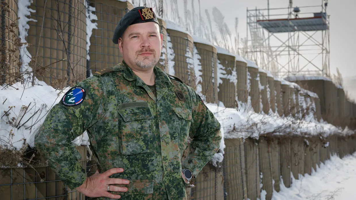 Een portretfoto van commandant Dijkshoorn met zijn armen in zijn zij. 