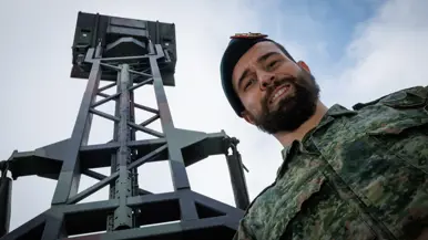 Een portretfoto van Jimmy met een radar op de achtergrond.