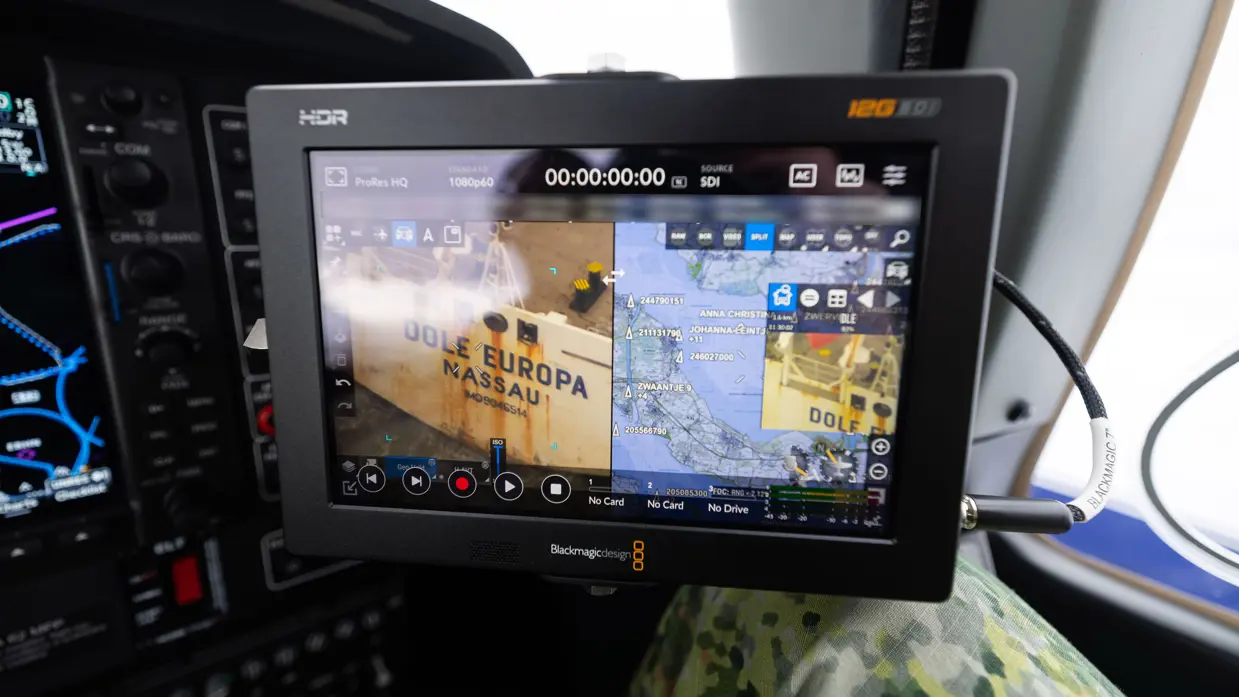 Een beeldscherm die camerabeelden toont in de cockpit van het patrouillevliegtuig.