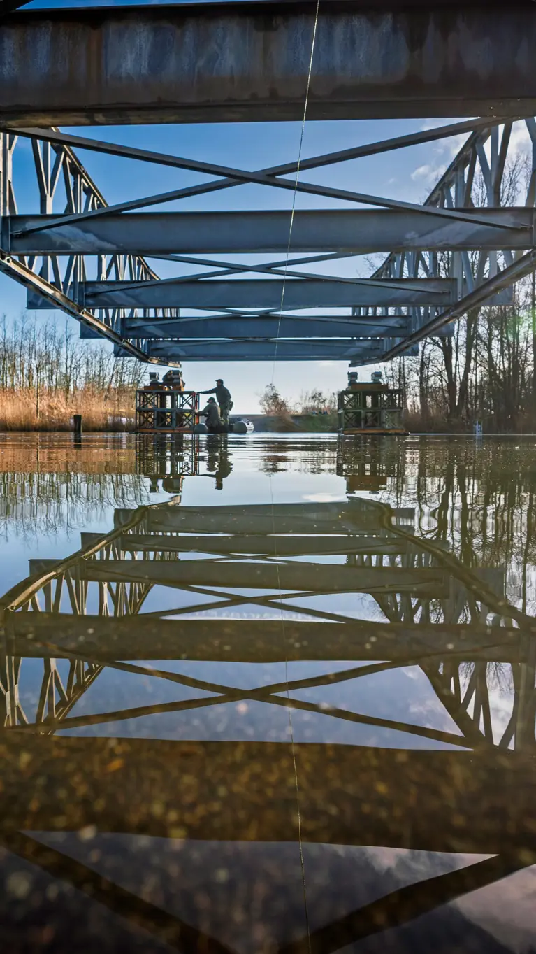 De constructiegenie legt een brug aan over het water.