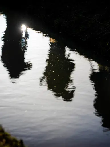 Weerspiegeling van militairen op het water.