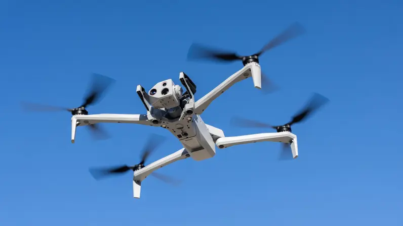 De drone van FO verkeer & visualisatie hangt in de lucht met de camera naar voren gericht en een blauwe lucht op de achtergrond.