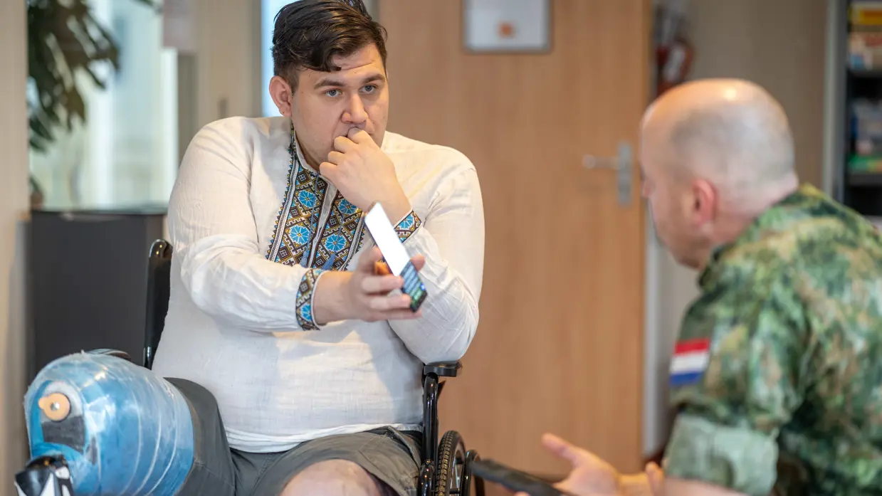 Een Oekraïense militair toont zijn smartphone aan de Nederlandse militair redacteur, en vice versa. 