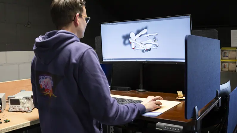 Een medewerker van research en development kijkt naar een 3D-tekening op z’n scherm.