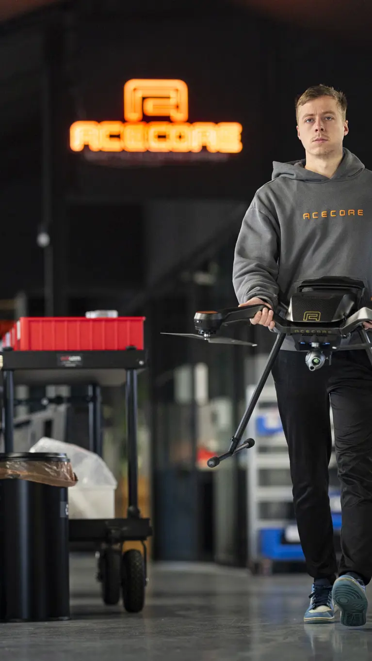 Een medewerker van Acecore loopt door de werkruimte met een drone.