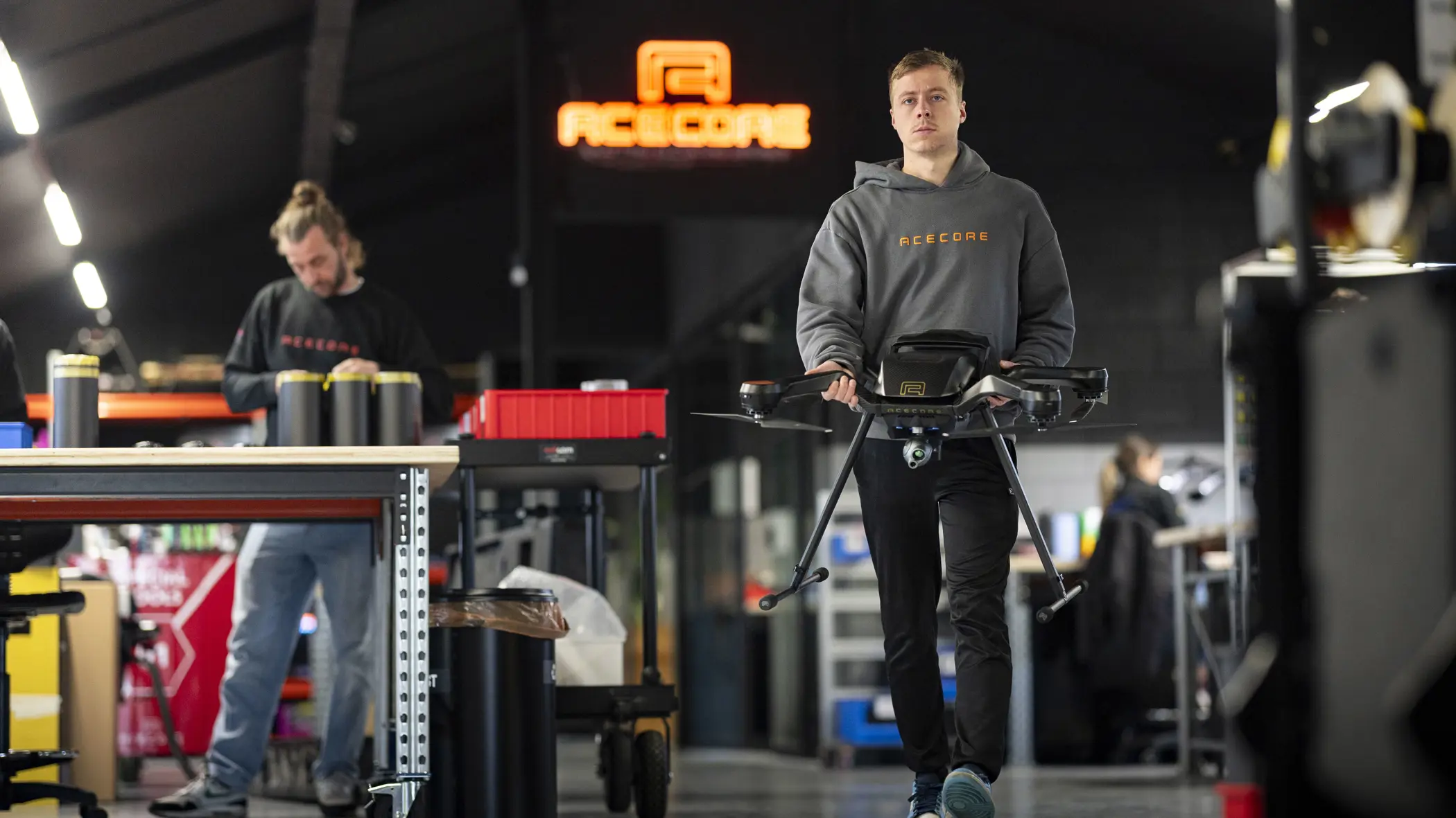 Een medewerker van Acecore loopt door de werkruimte met een drone.