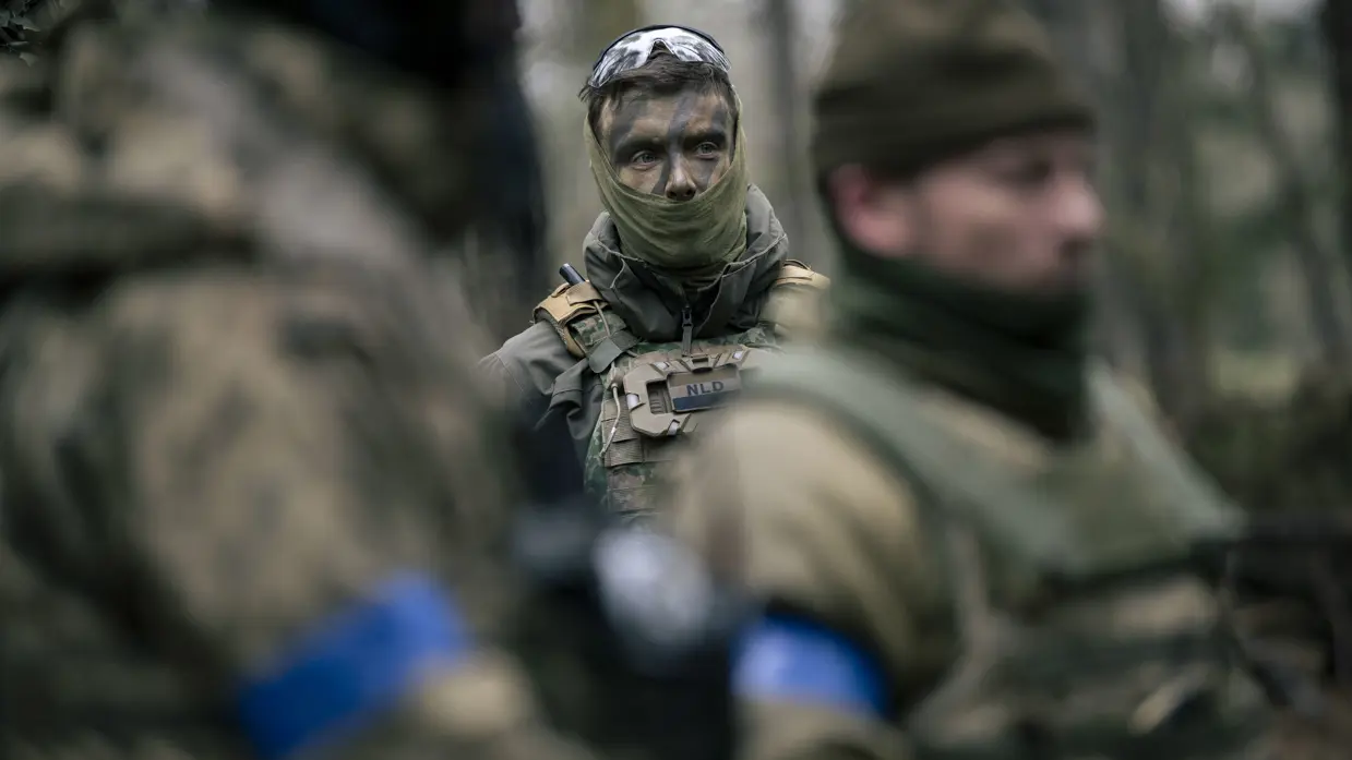 Luitenant Bas op de achtergrond en op de voorgrond onscherpe Oekraïense militairen. 