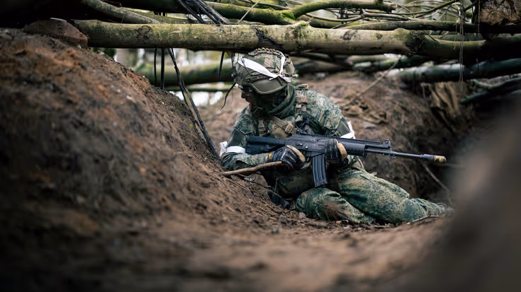 Militair in zand met wapen
