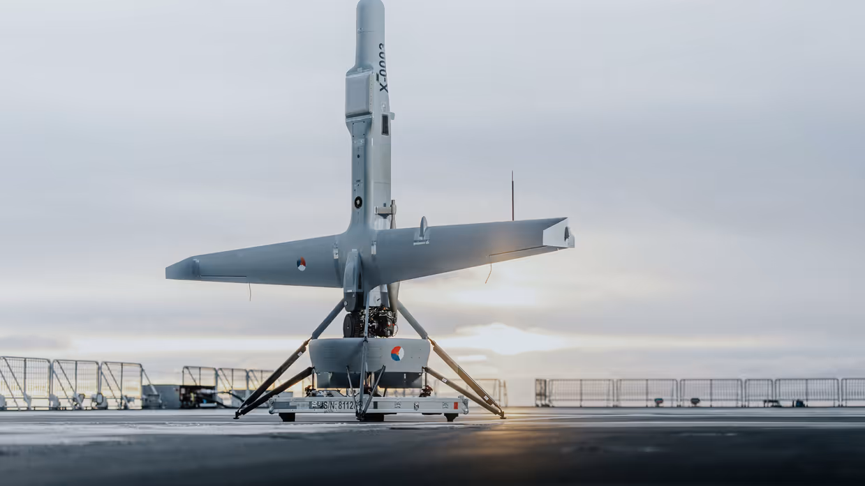 Een V-BAT drone staat naar boven gericht op het dek van een schip.