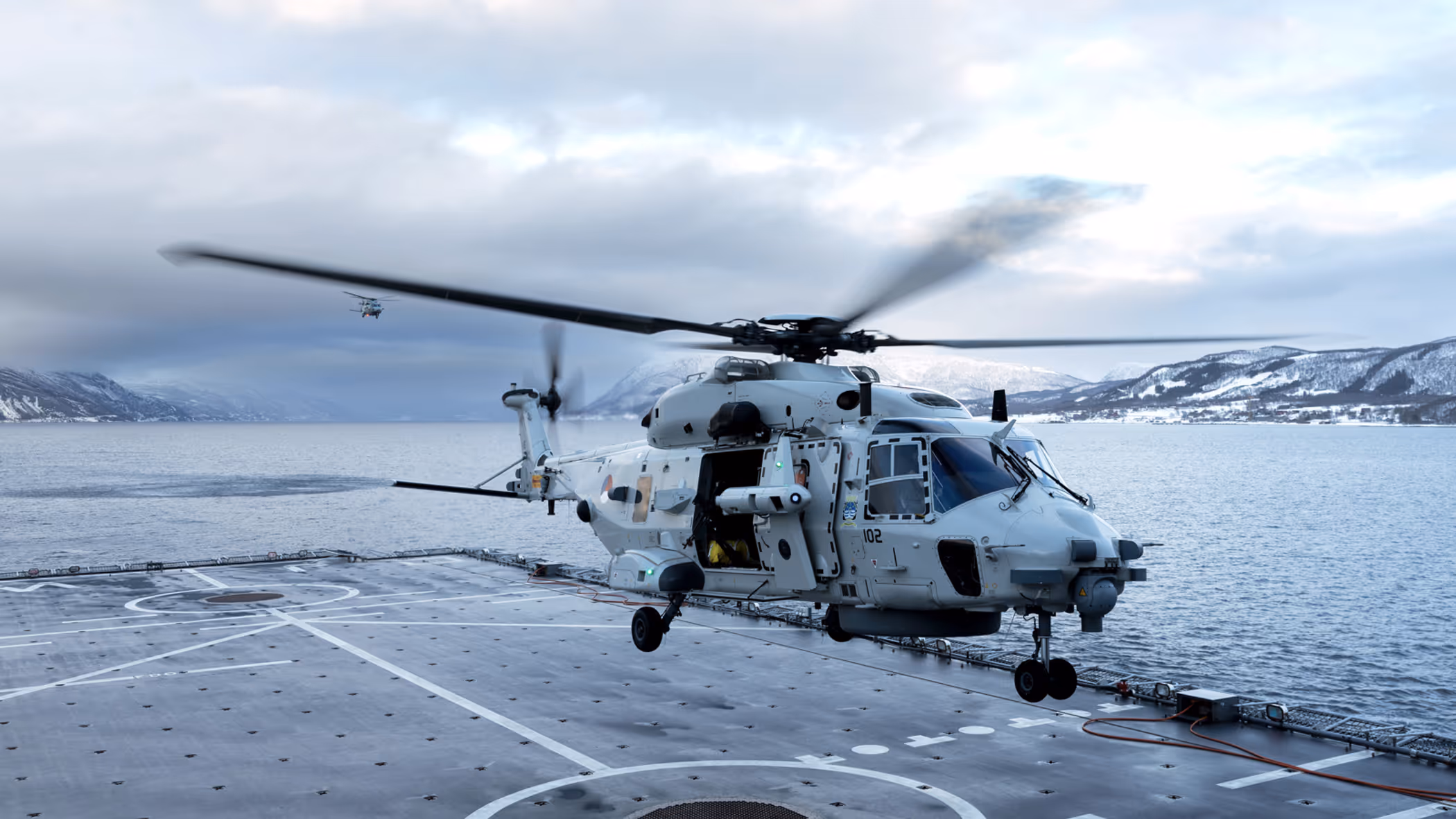 Een NH90 landt op het helikopterdek van een schip.