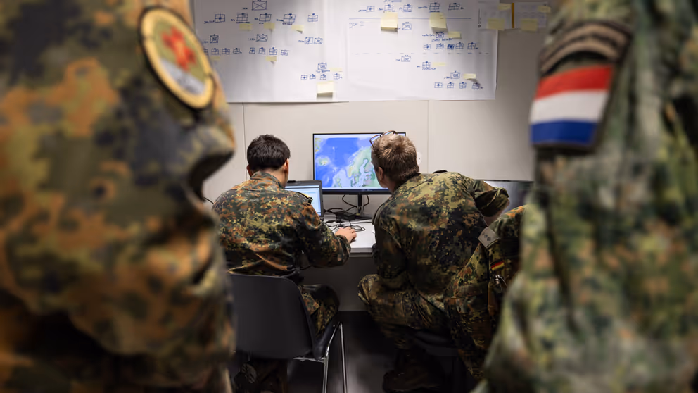 Militairen op de rug gezien, ze kijken naar een scherm.