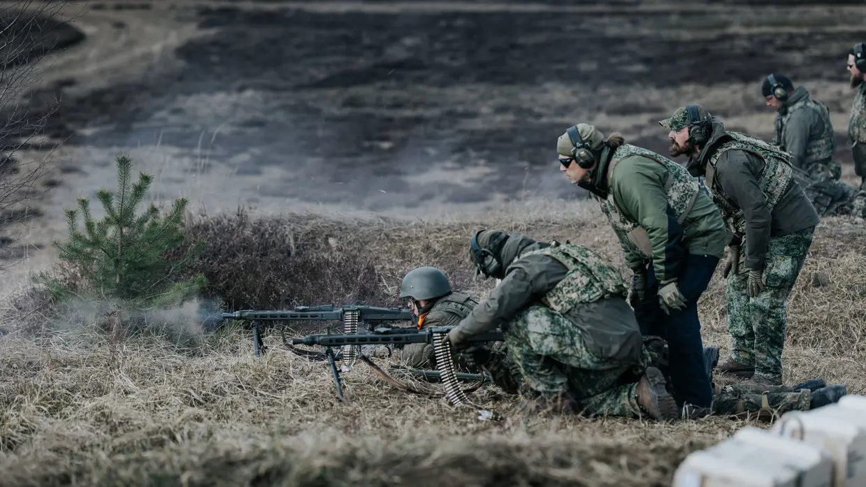 Oekraïners schieten vanuit loopgraaf, militair richt op klapschijven, Oekraïners liggen achter mitrailleur