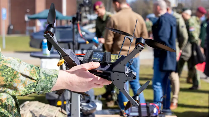 Militair houdt een kleine drone vast tijdens een demonstratie. 