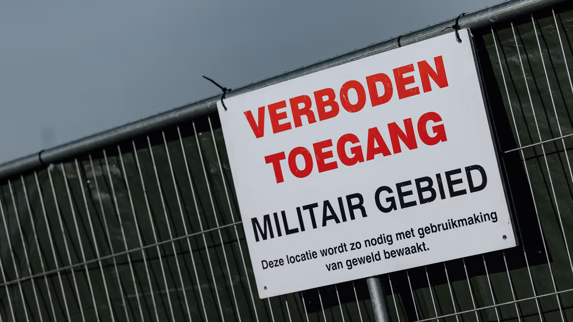 Wit bord met daarop de tekst: verboden toegang, militair gebied. 