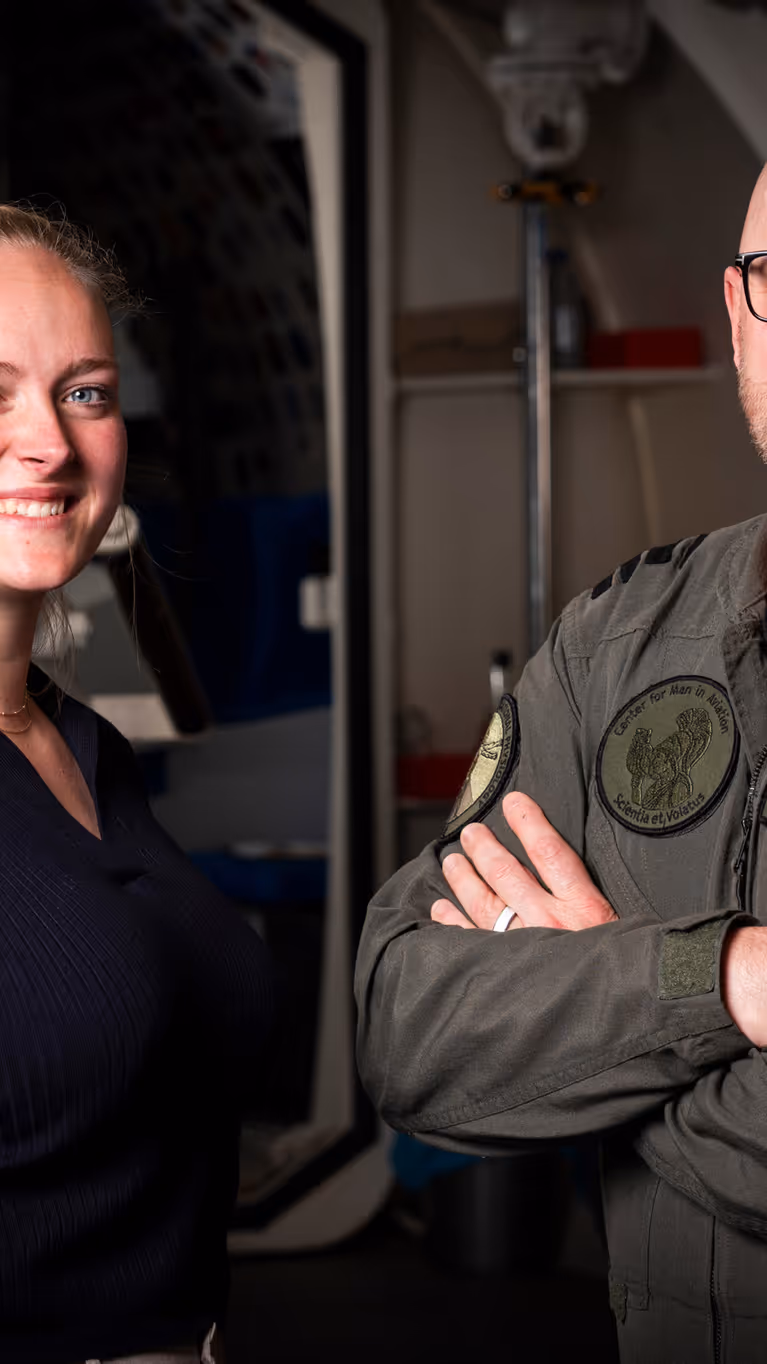 Vrouw in burgerkleding en man in militair uniform staan naast elkaar. 