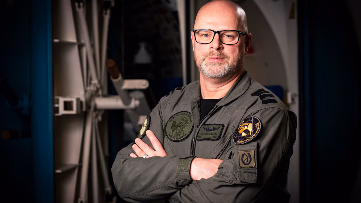 Militair met baard en bril kijkt vriendelijk in de camera. 