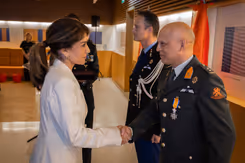 Minister van Defensie schudt de hand van gedecoreerden.