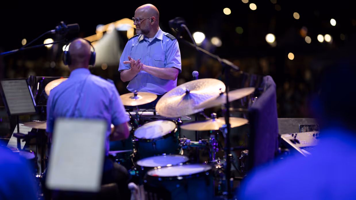 Dirigent klapt voor de drummer van het orkest. 