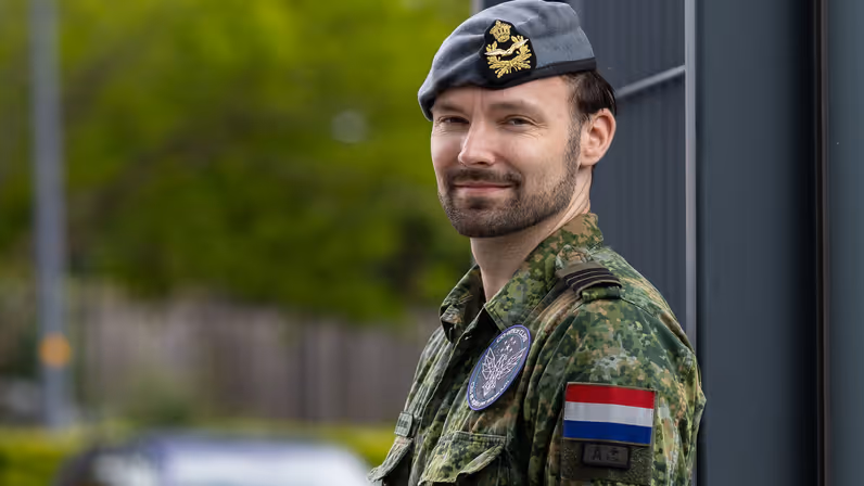 Michael van den Wildenberg draagt een groen vlekkenpak en kijkt in de camera.  